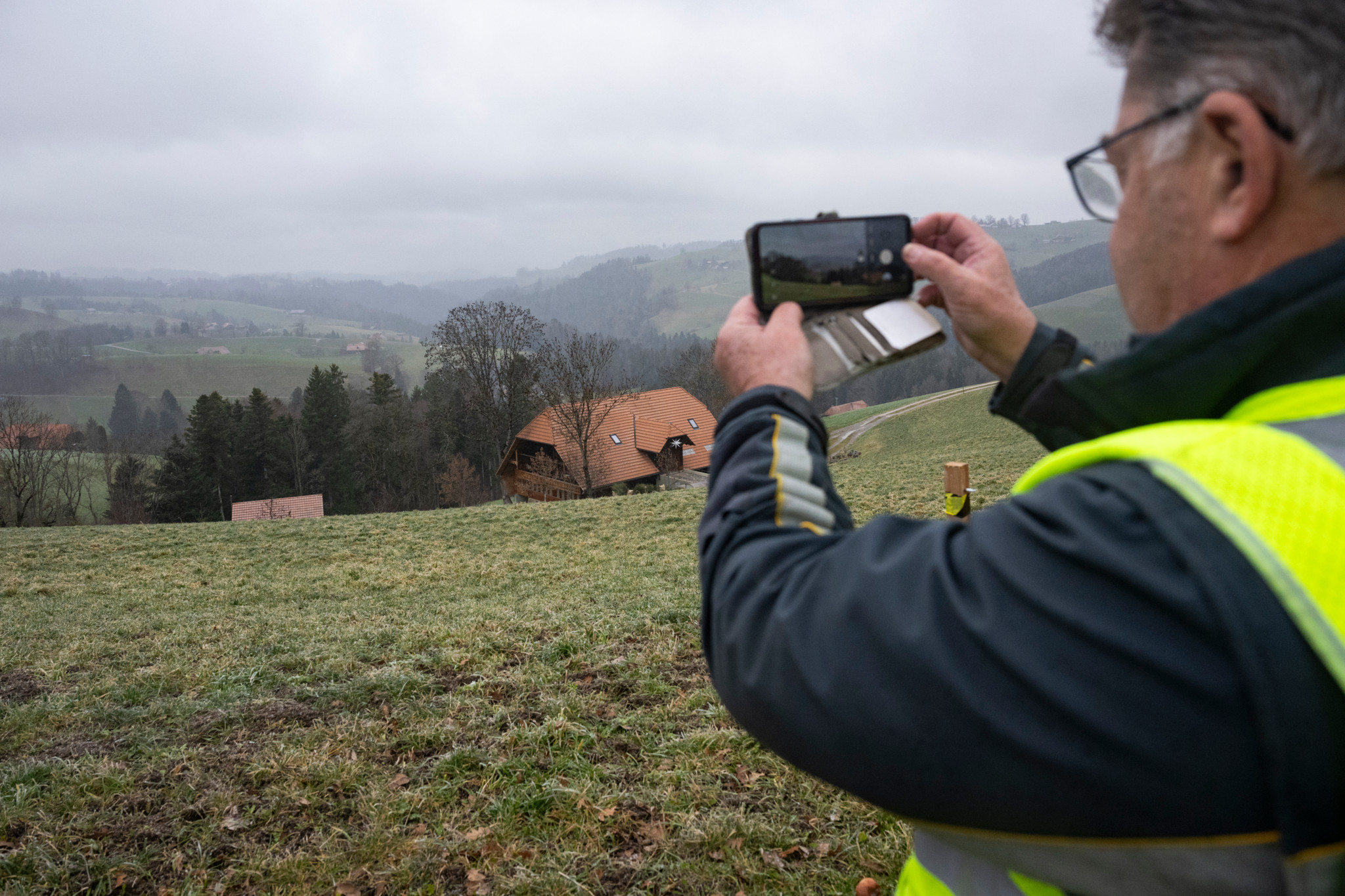 Briefträger Erich Marti fotografiert eine ländliche Landschaft in Hinterfultigen am 24. Dezember 2025.