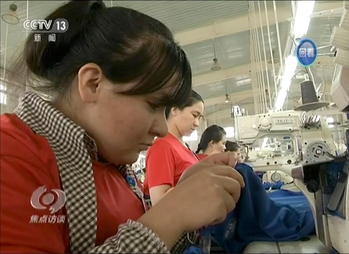 Des stagiaires musulmans travaillent dans une usine de confection du centre d'enseignement et de formation professionnels de Hotan à Hotan, Xinjiang, dans le nord-ouest de la Chine. Image tirée d’un reportage diffusé par la télévision chinoise. 