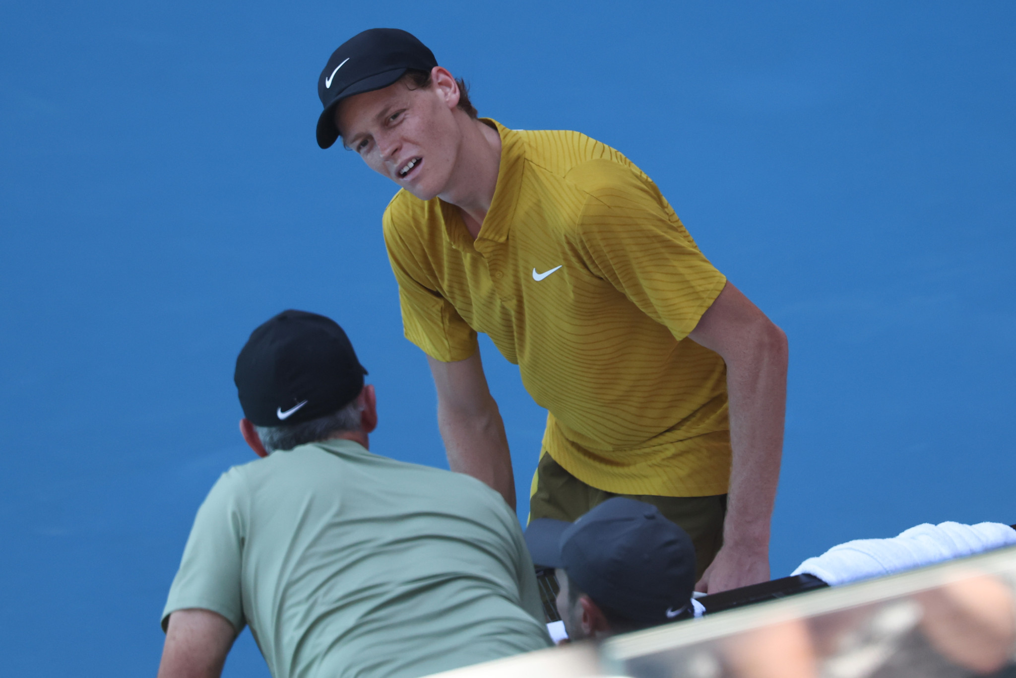 Jannik Sinner speaks to his team at the Australian Open 2026 in Melbourne during a match against Eliot Spizzirri.