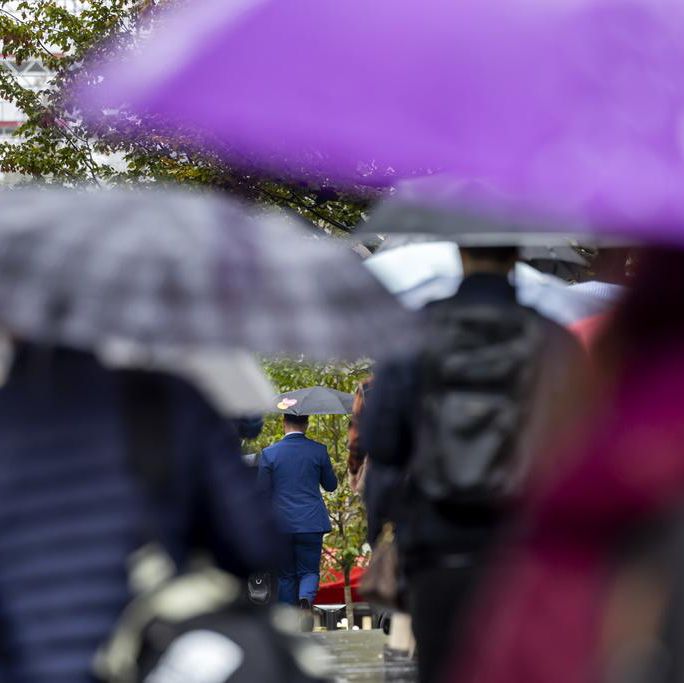Des personnes marchant sous des parapluies sur la rue du Mont-Blanc à Genève sous une pluie battante, le 8 octobre 2024.