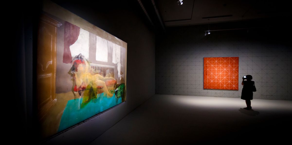 Une femme visite l'exposition 'Balthus Unfinished' à Lausanne, présentant des œuvres inachevées de l'artiste Balthus dans un site de construction.