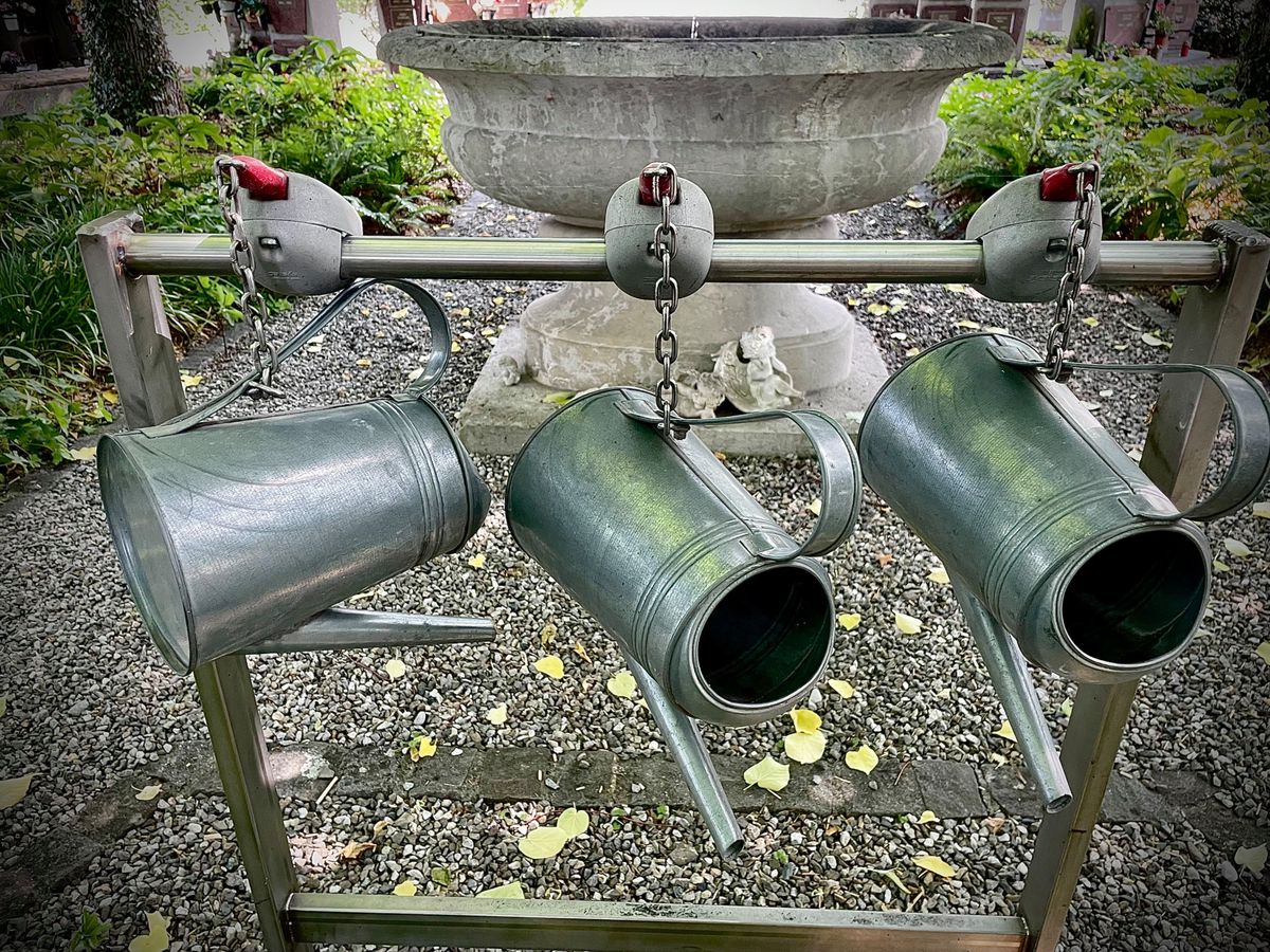 Un trio d’arrosoirs au columbarium du cimetière de Lancy.