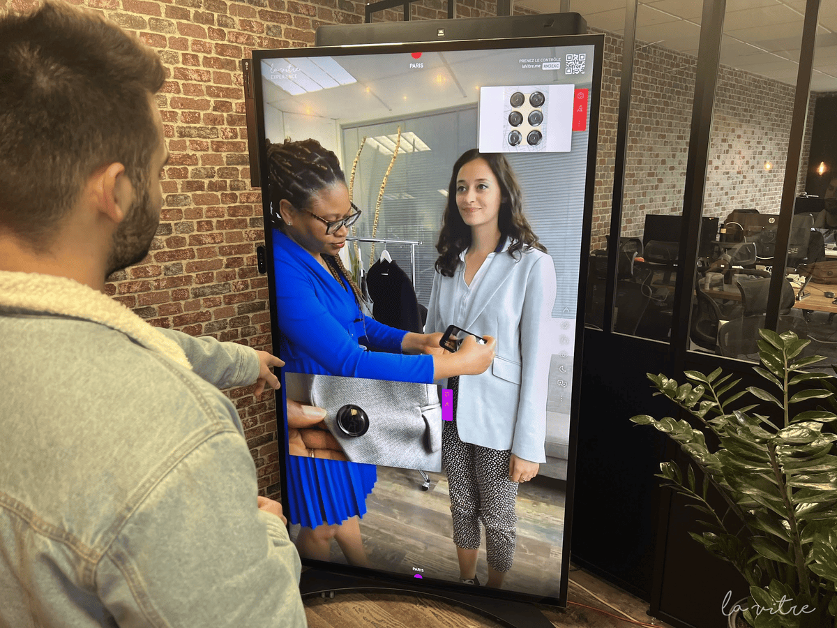 Deux personnes se regardent dans une vitre technologique