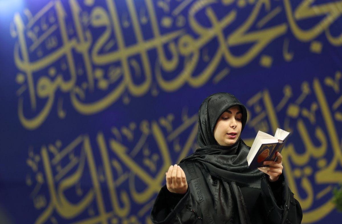 Une femme iranienne prie en tenant le Coran lors d’une cérémonie religieuse au mausolée Saleh à Téhéran, pendant le Ramadan.