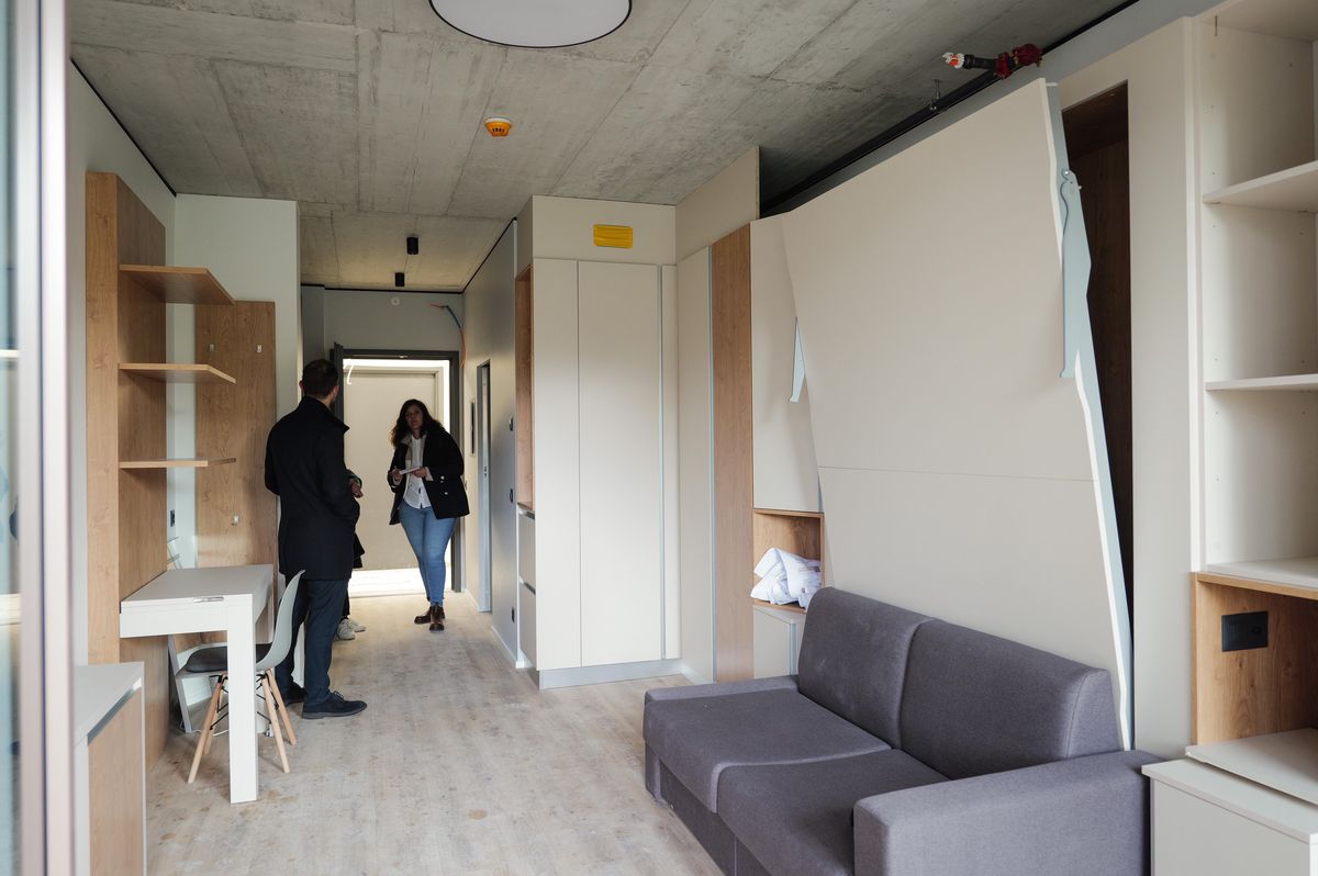 Visite d'un micro-logement City Pop à Surville, Lancy. Intérieur moderne avec mobilier modulable et espace optimisé.