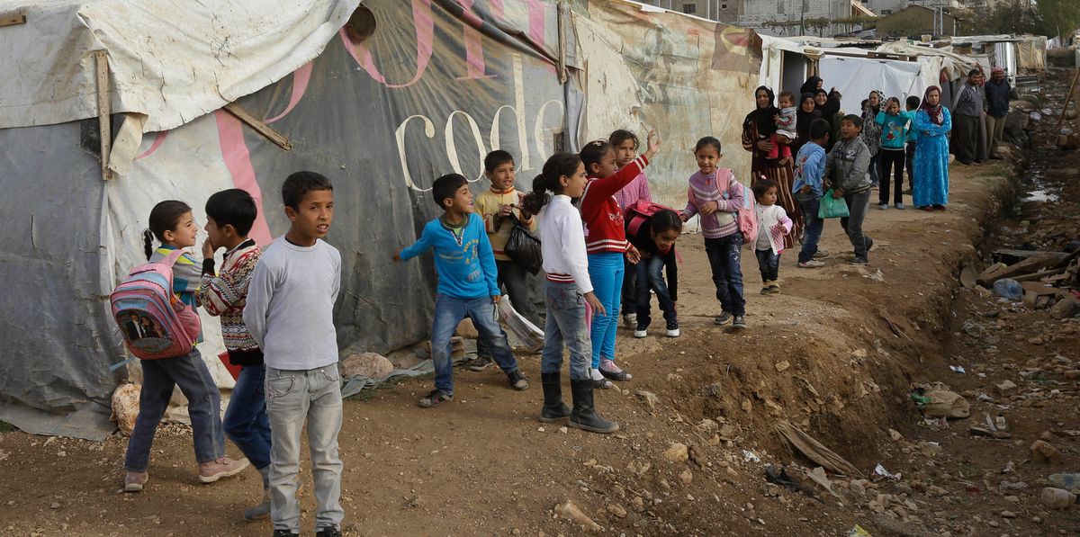 Syrian displaced children wait outside their tents for the arrival of French President Francois Hollande's companion Valerie Trierweiler, during her visit to one of the Syrian refugee camp, at Delhamiyeh village in the Bekaa valley, eastern Lebanon, Tuesday, Nov. 5, 2013. Trierweiler is in Lebanon for two-day visit to attend the Francophone Book Fair and to visit Syrian refugees. There are more than 800,000 refugees registered with the U.N. refugees agency in Lebanon, but the Lebanese government estimates the real number of Syrians in the country at more than 1 million, or around one-third of the tiny country’s population. (AP Photo/Hussein Malla)