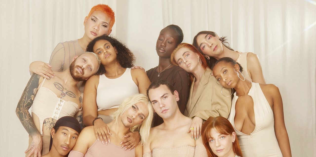 Un groupe de mannequins divers posé dans des vêtements neutres et minimalistes devant un fond blanc.