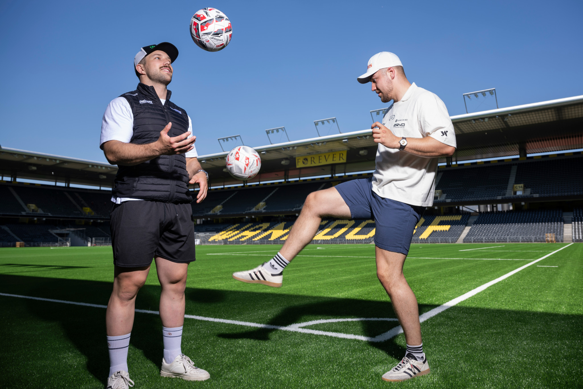 Schwinger Fabian Staudenmann und Adrian Walther spielen mit Fussball im Stade de Suisse in Bern bei strahlendem Sonnenschein. Schwinger Fabian Staudenmann und Adrian Walther spielen mit Fussball im Stade de Suisse in Bern bei strahlendem Sonnenschein.