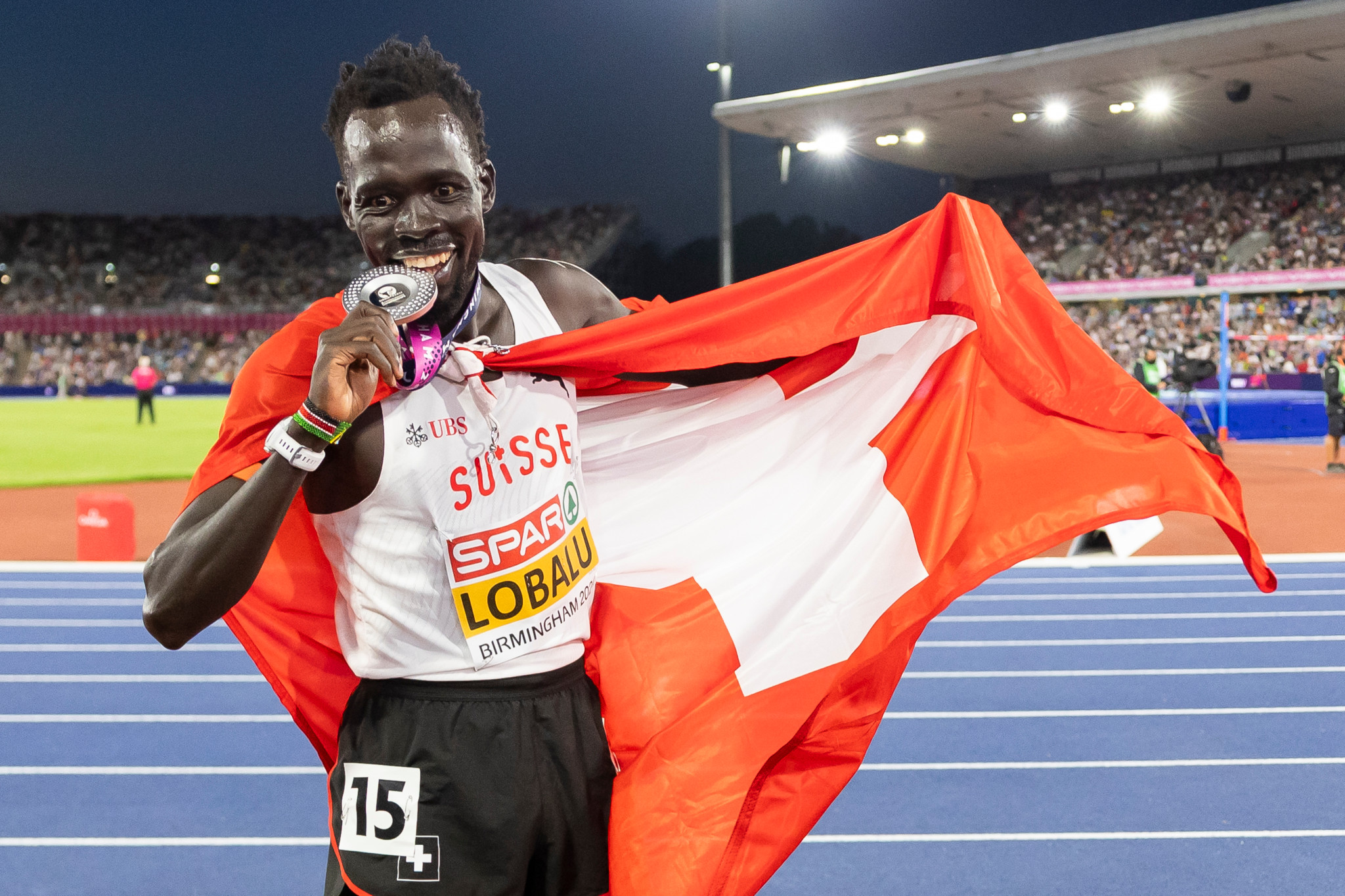 Dominic Lobalu hält seine Silbermedaille und die Schweizer Fahne beim 10.000-Meter-Finale der Leichtathletik-EM im Alexander Stadium in Birmingham.