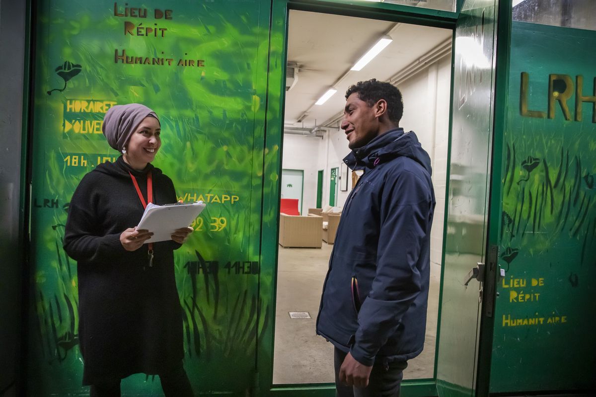 Genève, le 14 novembre 2022. Un bénéficiaire se présente à l’entrée du lieu de répit humanitaire (LRH) à Plan-les-Ouates. Il est accueilli par Sarah, travailleuse sociale. © Magali Girardin