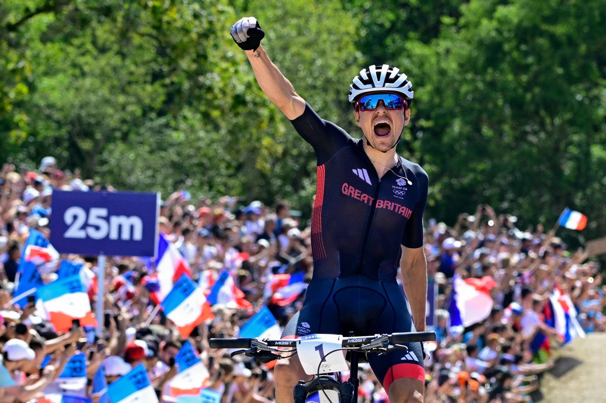 Britain's Thomas Pidcock celebrates his victory after winning the men's cross-country mountain biking event during the Paris 2024 Olympic Games in Elancourt Hill venue in Elancourt, on July 29, 2024. (Photo by John MACDOUGALL / AFP)