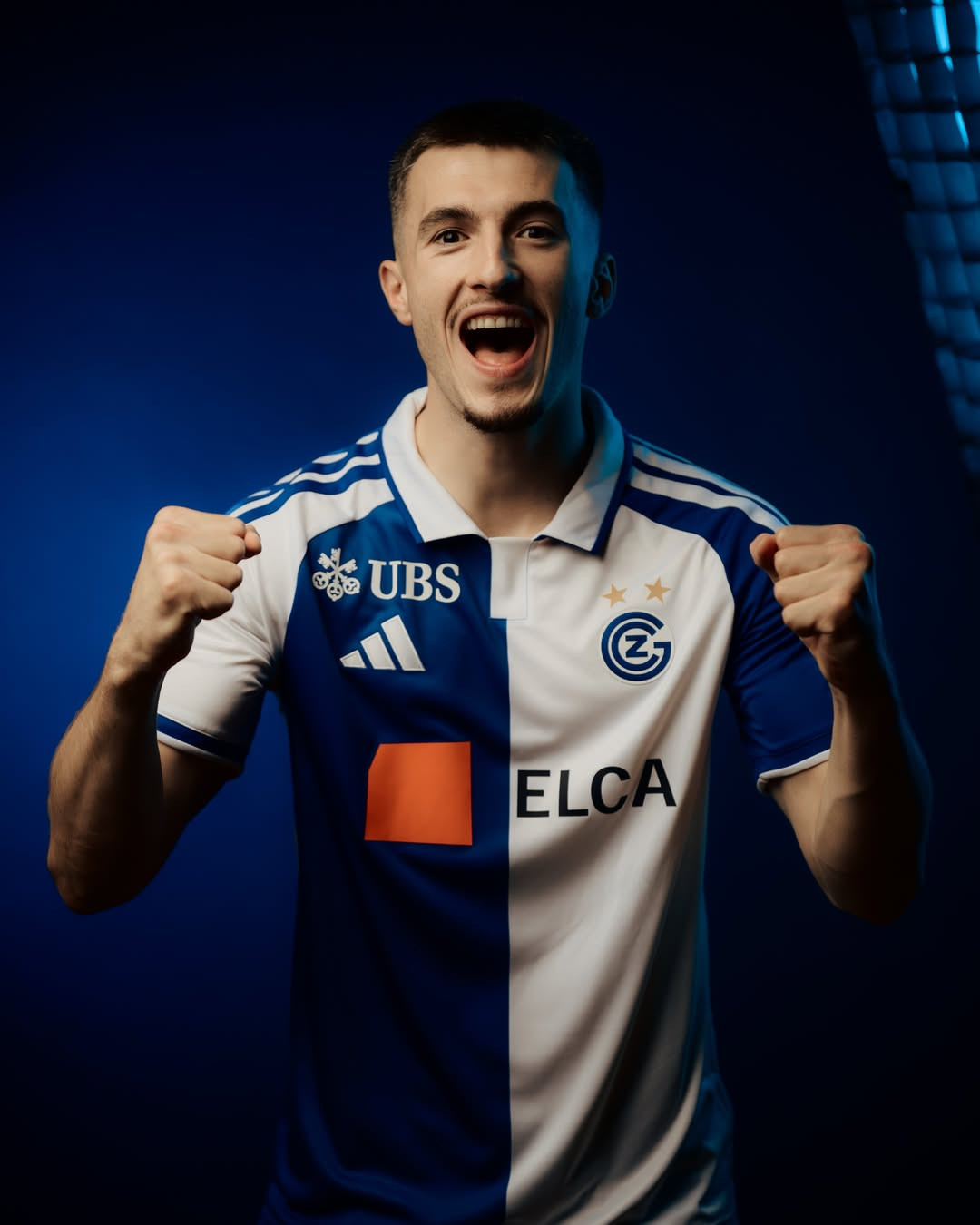 Junger Fussballspieler im blau-weissen GC-Trikot mit UBS- und ELCA-Sponsoren ballt jubelnd die Fäuste.