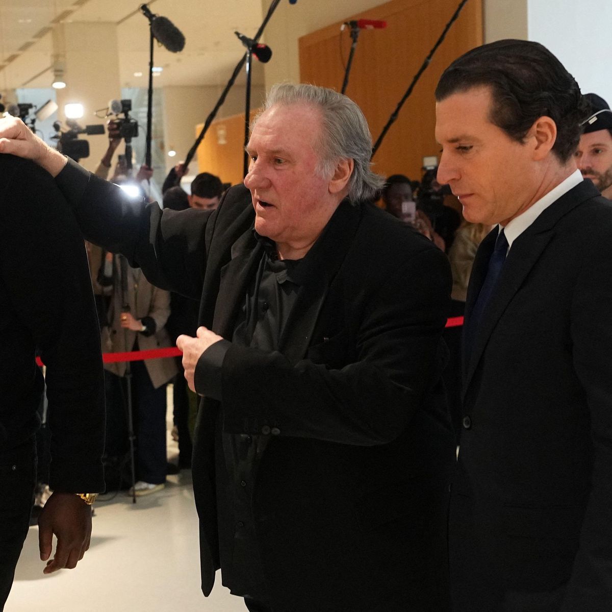 Gérard Depardieu, au centre, avec son avocat Jérémie Assous à droite, quittent le tribunal de Paris lors de son procès pour agression sexuelle le 25 mars 2025.