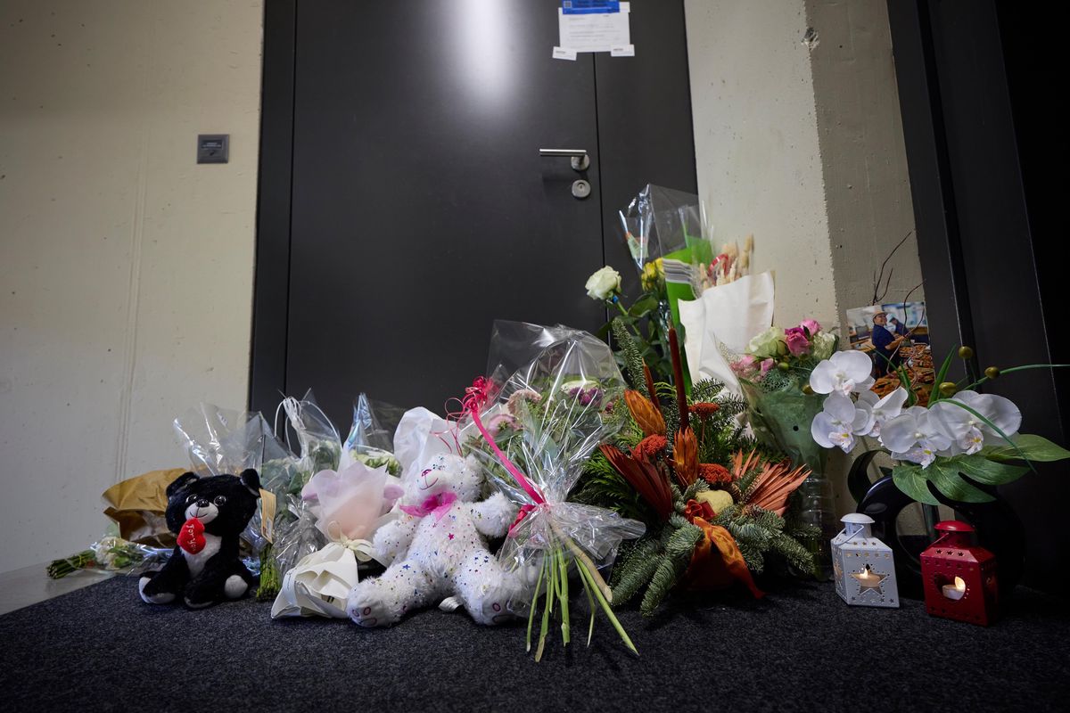 Des fleurs et des peluches déposées devant la porte d'un appartement à La Chaux-de-Fonds en hommage à une tragédie familiale.