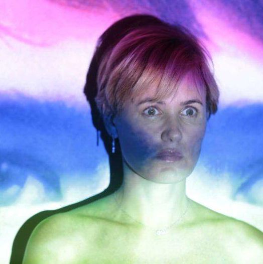 Femme avec projection colorée sur le visage, yeux en arrière-plan.