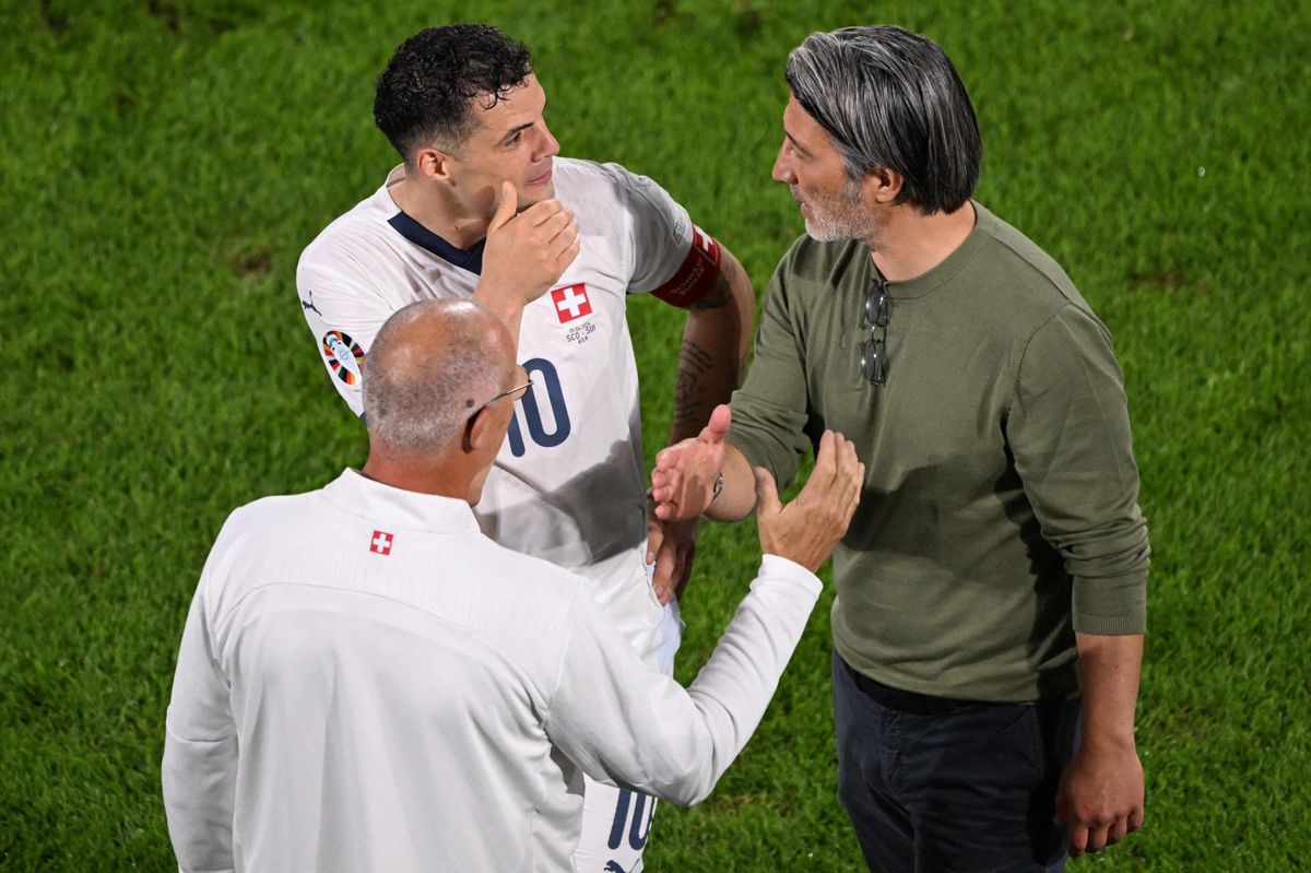 Switzerland's midfielder #10 Granit Xhaka speaks with Switzerland's head coach Murat Yakin (R) at the end of the UEFA Euro 2024 Group A football match between Scotland and Switzerland at the Cologne Stadium in Cologne on June 19, 2024. (Photo by Kirill KUDRYAVTSEV / AFP)