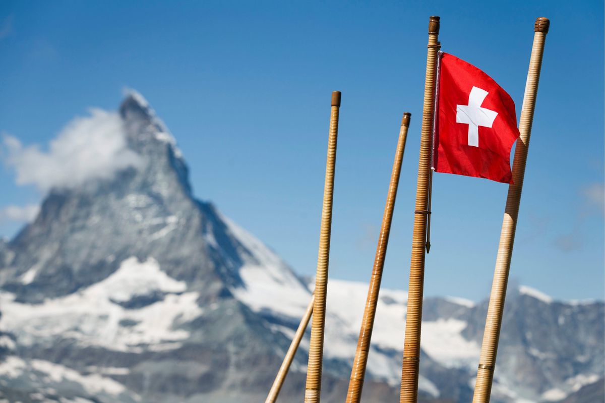 Un drapeau suisse et des cors des Alpes devant le Cervin, au-dessus de Zermatt, en août 2013. 