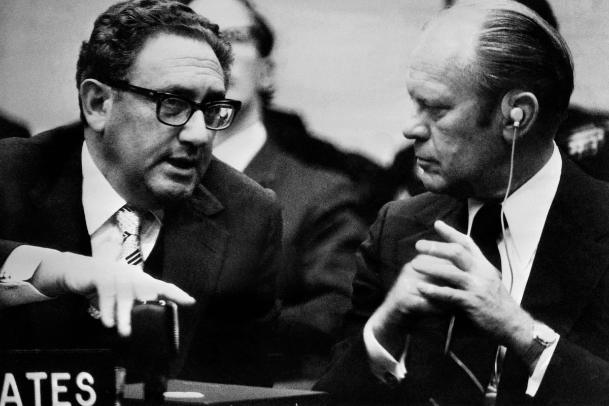 (FILES) US Secretary of State Henry Kissinger (L) speaks with US President Gerald Ford during the NATO 1975 summit on May 29, 1975 in Brussels. Former US secretary of state Henry Kissinger, a key figure of American diplomacy in the post-World War II era, died November 29, 2023 at the age of 100, his association said. (Photo by AFP)