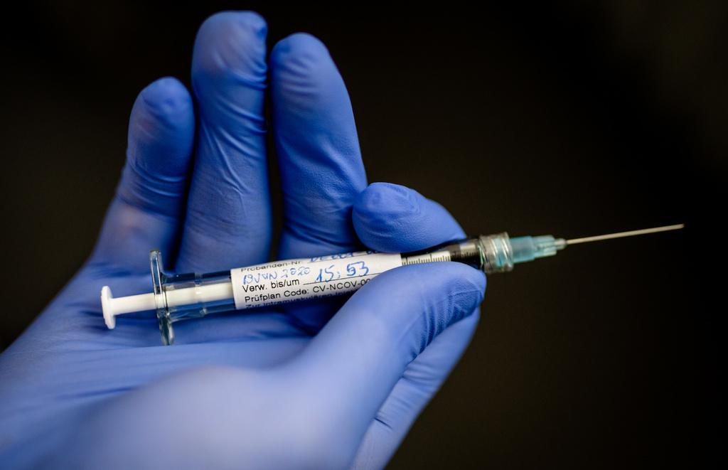 Im Januar soll auch in der Schweiz geimpft werden: Ein Mann hält eine Spritze in der Hand, mit der einer erste Probandin in Deutschland ein möglicher Wirkstoff gegen das Coronavirus gespritzt wurde. 