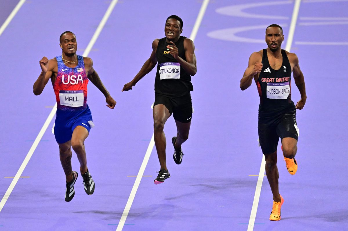 US' Quincy Hall (L) competes to win ahead of Britain's Matthew Hudson-Smith (R) and Zambia's Muzala Samukonga (C) in the men's 400m final of the athletics event at the Paris 2024 Olympic Games at Stade de France in Saint-Denis, north of Paris, on August 7, 2024. (Photo by Martin  BERNETTI / AFP)