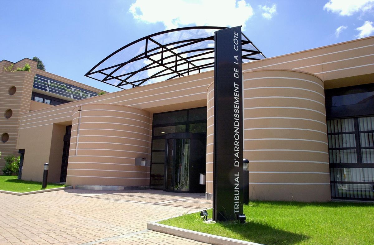 Entrée moderne du Tribunal d'arrondissement de La Côte avec une façade en courbes beiges et un auvent en verre.