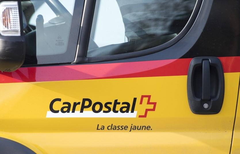 Logo CarPostal sur un bus jaune et rouge près de la gare d'Avenches, photographié le 9 février 2018.