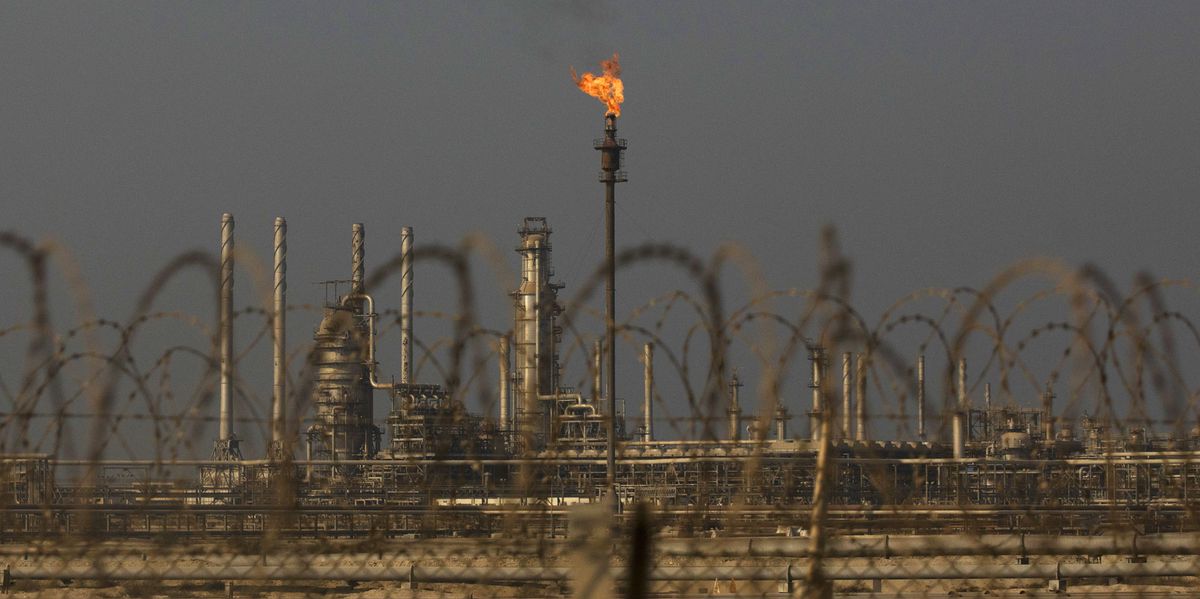 Flamme brennt auf einem Abfackelstapel in der Saudi Aramco-Raffinerie Ras Tanura, mit Industrieanlagen im Hintergrund.