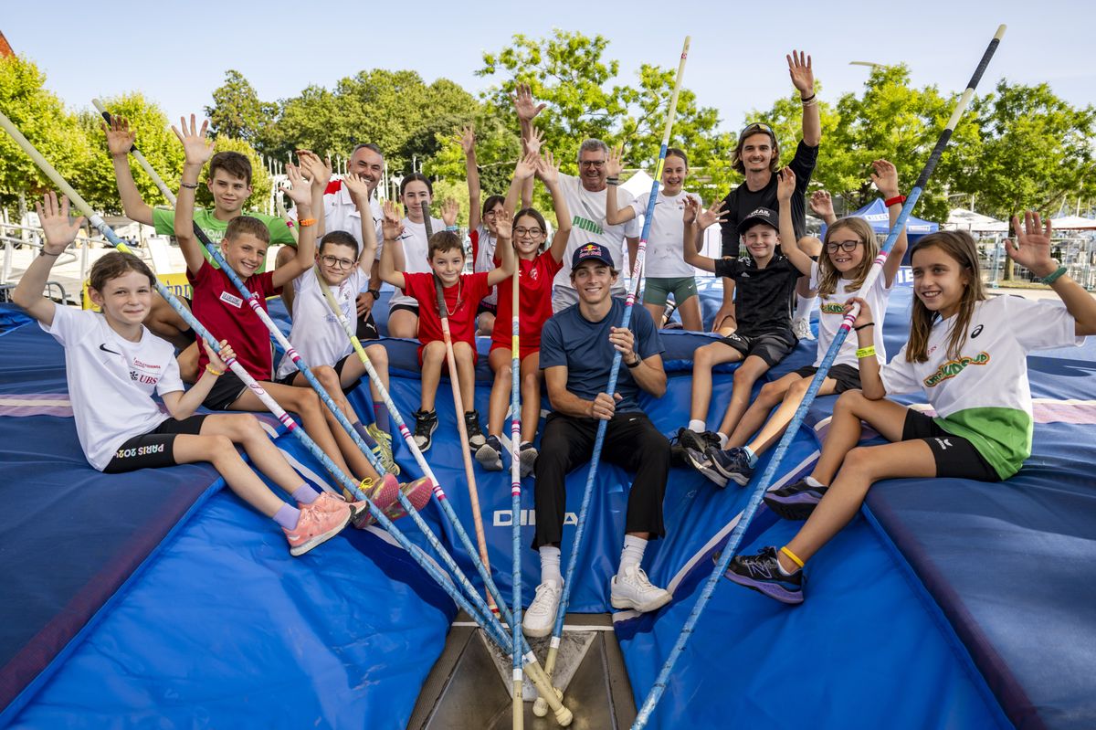 Armand Duplantis, champion olympique suédois du saut à la perche, pose avec de jeunes athlètes lors d'une séance d'entraînement à Lausanne avant le meeting Athletissima, mardi 20 août 2024.