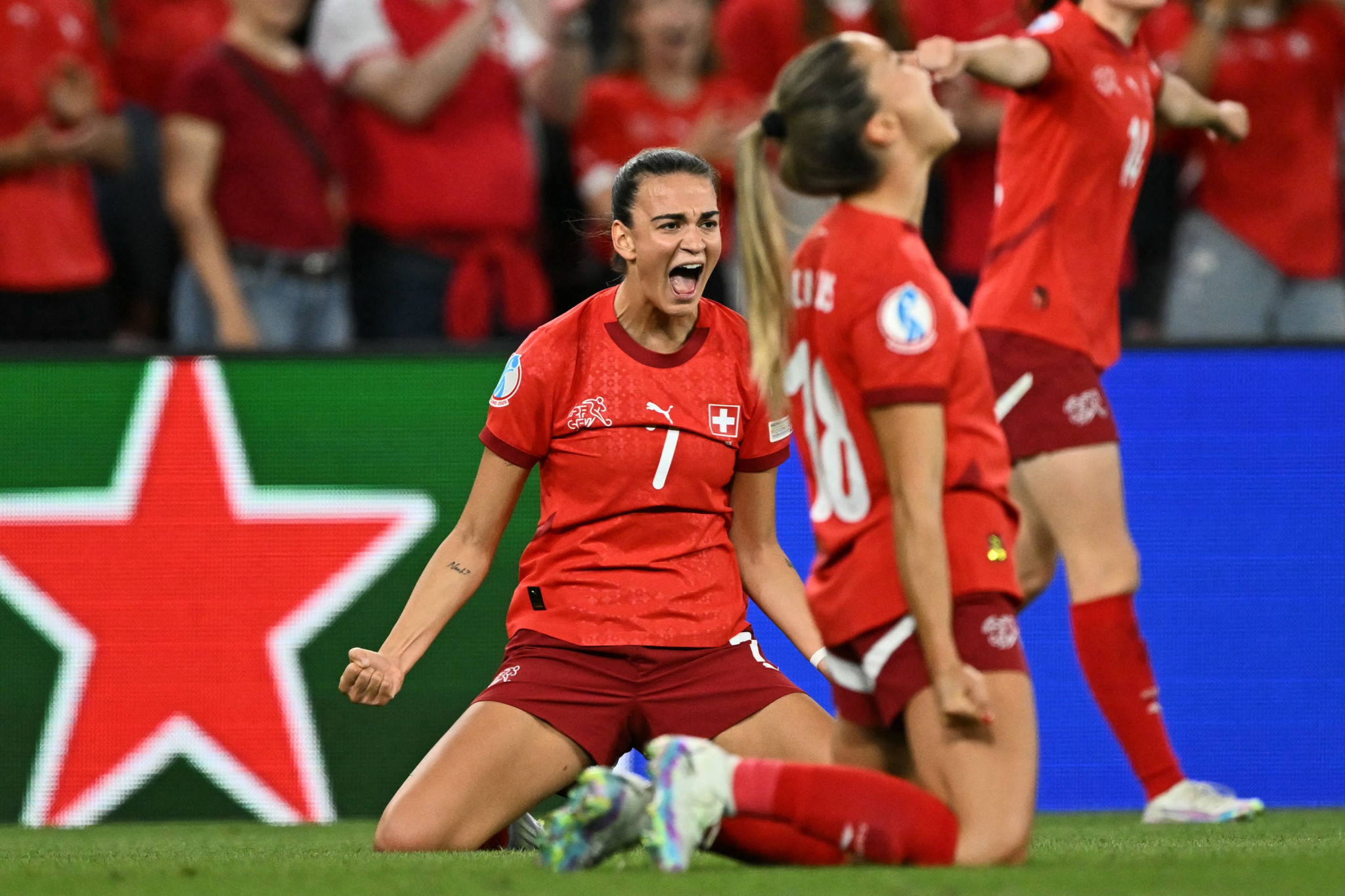 Fünf lachende Frauen im roten Trikot der Schweizer Nationalmannschaft feiern die Qualifikation für das Viertelfinale. Text: ’QUALIFIED, Next stop: Quarter Final, @swissnatwomen’.