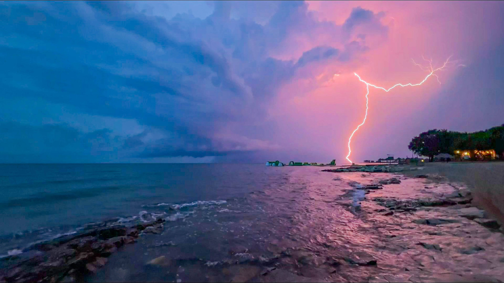 Gewitterfront über der kroatischen Adriaküste, mit einem intensiven Blitzschlag über dem Meer und dramatisch bewölktem Himmel.