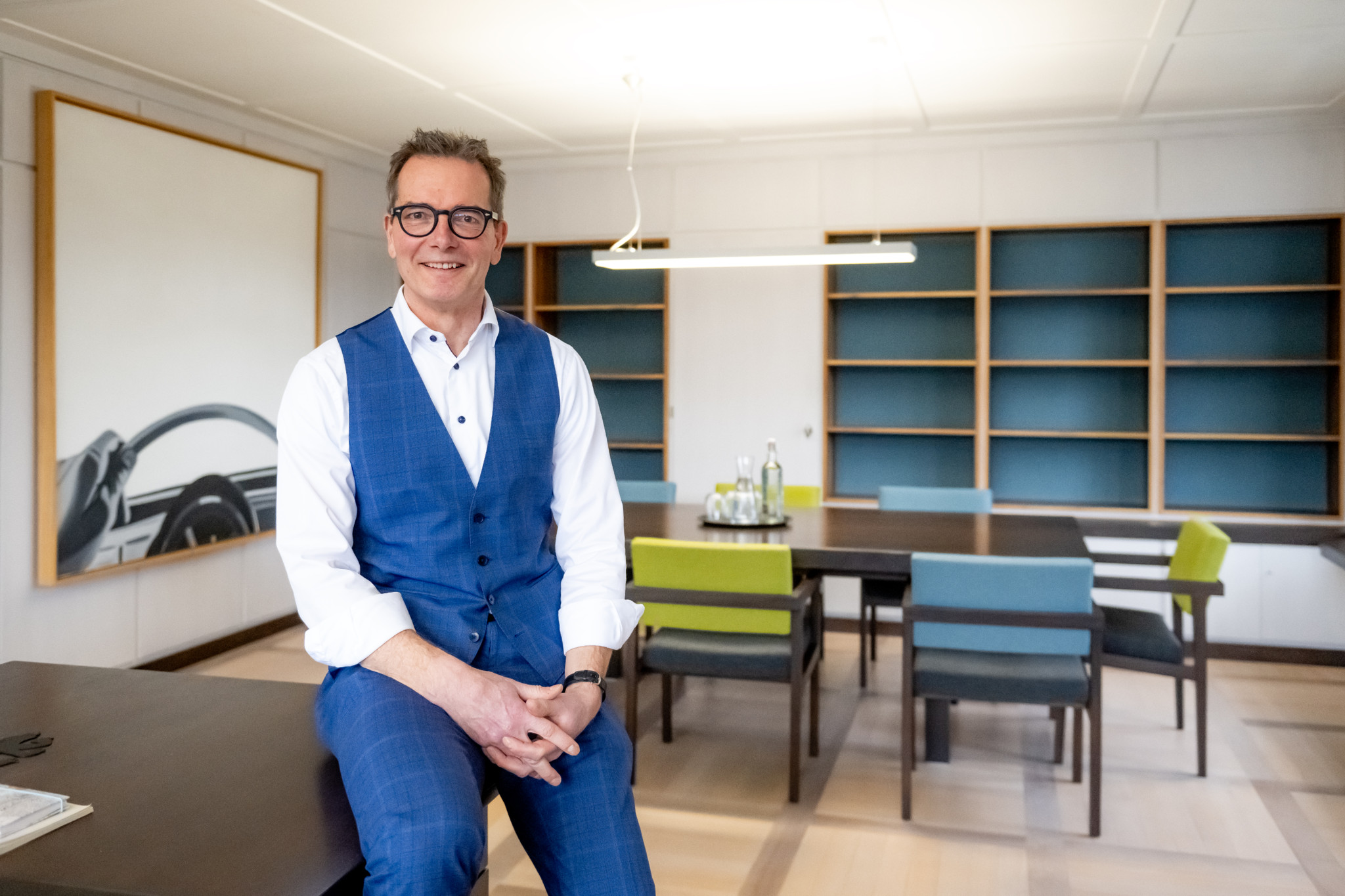 Der Thuner Stadtpräsident Raphael Lanz sitzt in seinem Büro, lächelnd und in einem blauen Anzug.