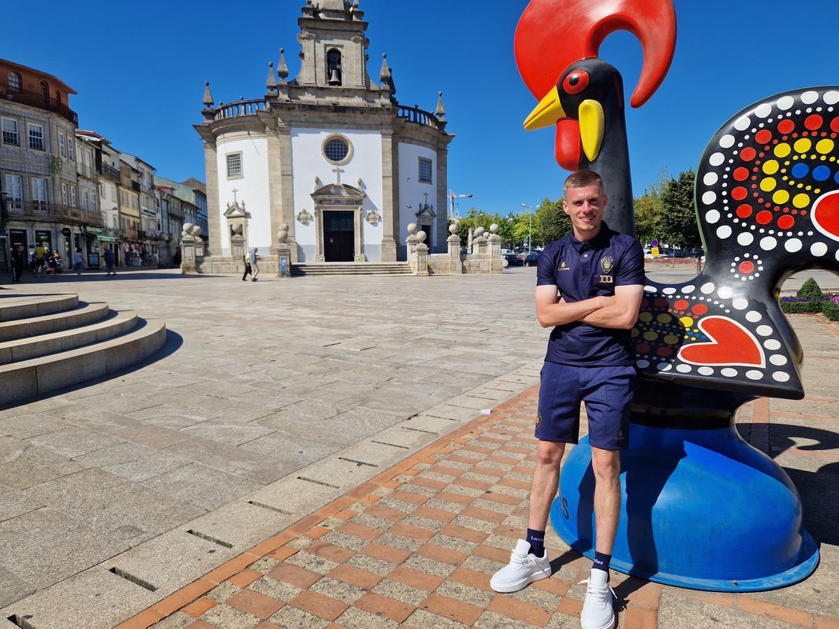 Maxime Dominguez pose devant le coq de Barcelos, le symbole national portugais originaire de cette même ville.