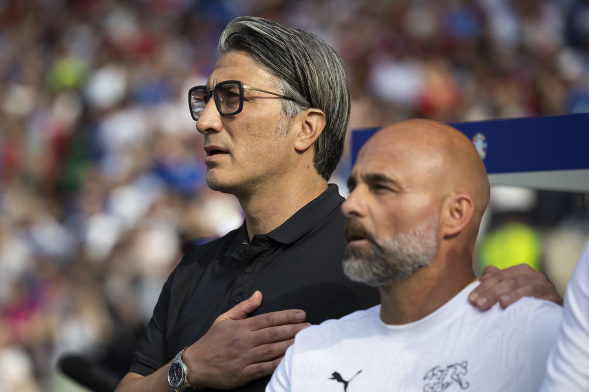 Murat Yakin, left, and assistant coach Giorgio Contini sing the national anthem prior to a round of 16 match between Switzerland and Italy at the Euro 2024 soccer tournament in Berlin, Germany, Saturday, June 29, 2024. (KEYSTONE/Peter Klaunzer)