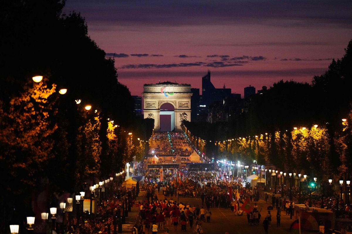 Des athlètes de différentes délégations défilent sur l'avenue des Champs-Elysées avec l'Arc de Triomphe en arrière-plan, lors de la cérémonie d'ouverture des Jeux Paralympiques de Paris 2024, le 28 août 2024.