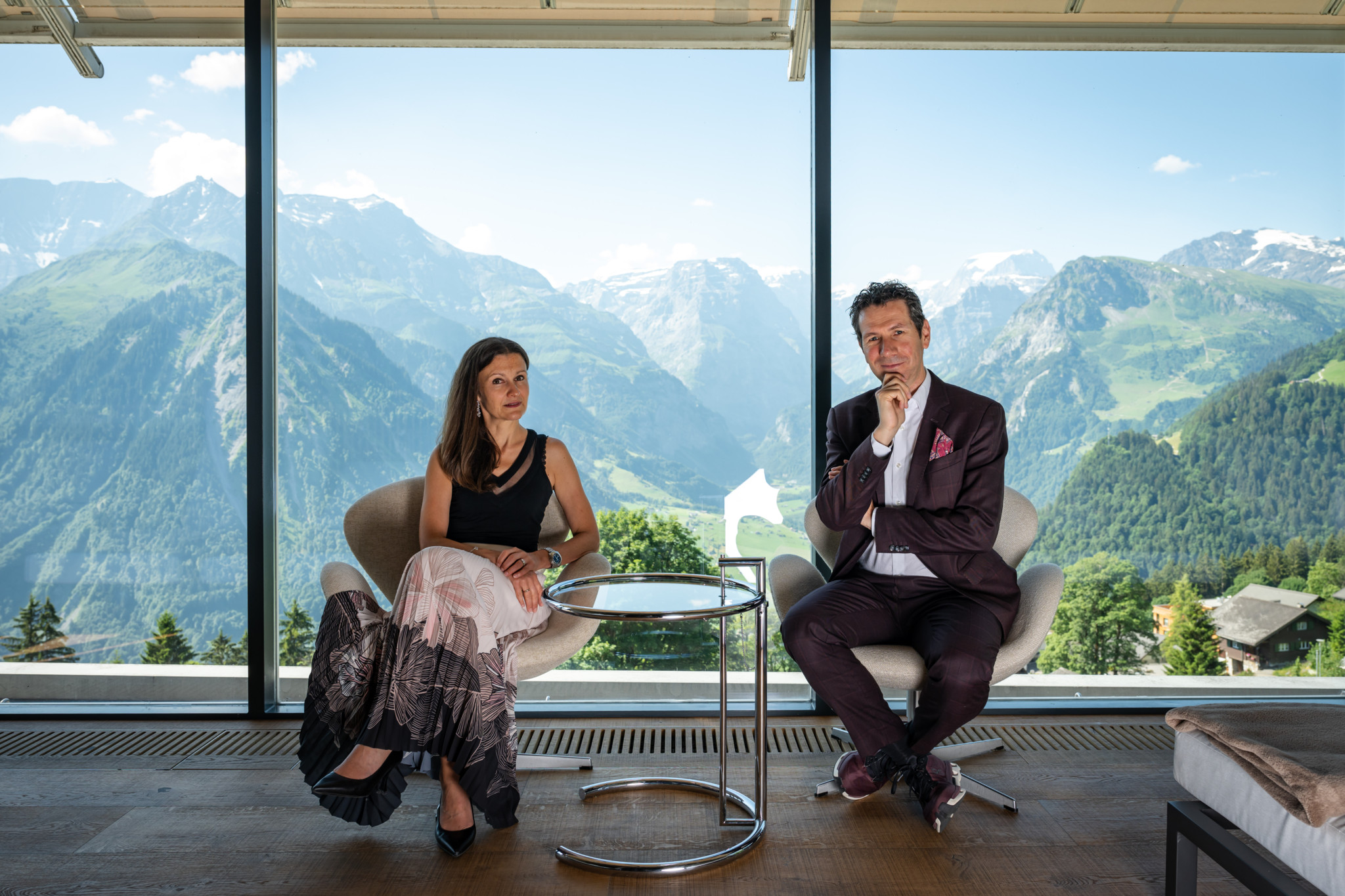 Patric und Nadja Vogel, Hoteliers in Braunwald, streicheln Lamas auf einer Bergwiese mit Alpenpanorama im Hintergrund. Patric und Nadja Vogel, Hoteliers in Braunwald, streicheln Lamas auf einer Bergwiese mit Alpenpanorama im Hintergrund.