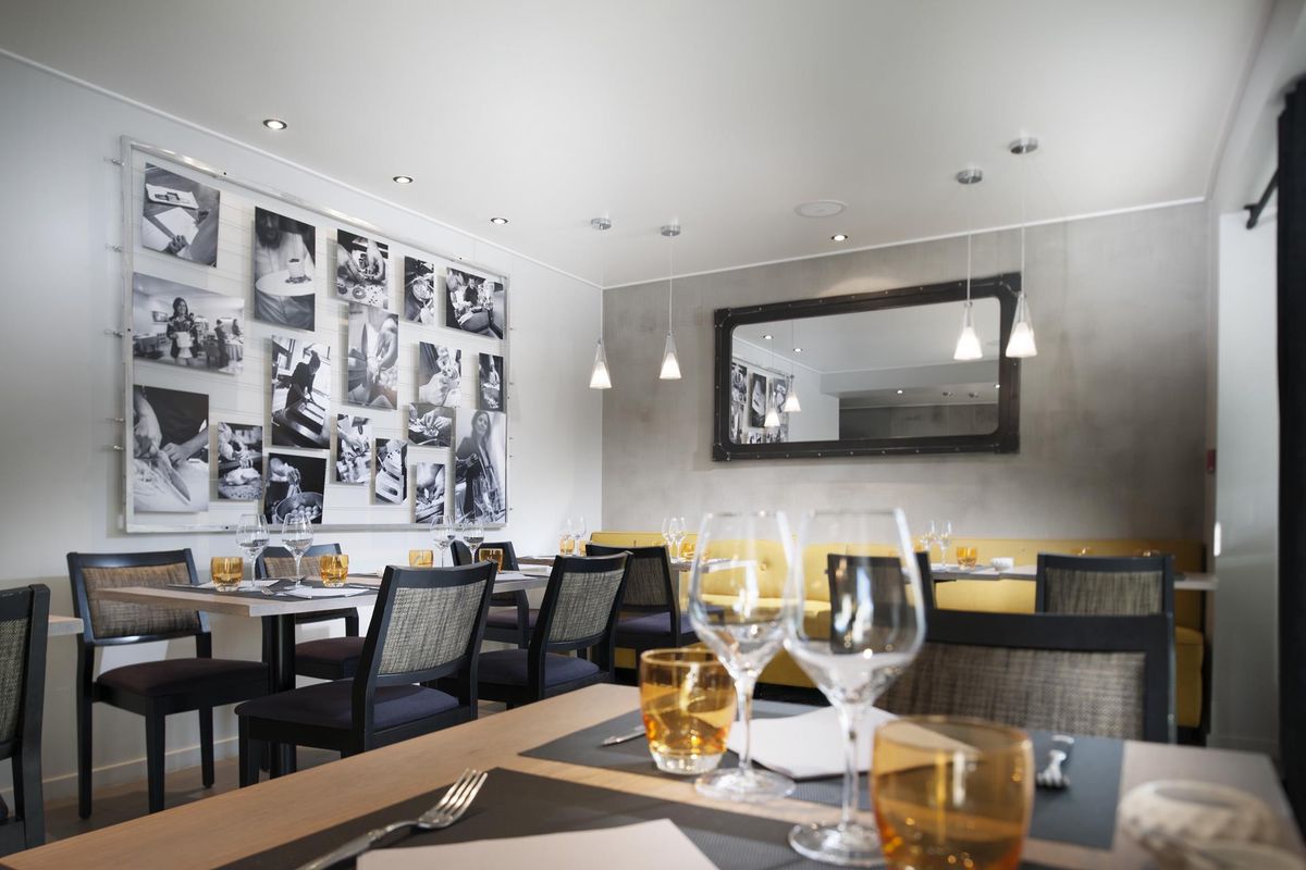 Une belle salle avec des photos du travail en cuisine au mur.