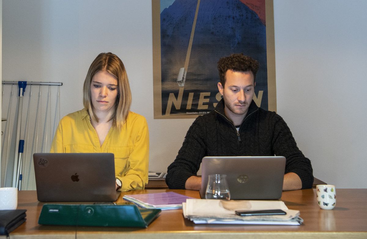 Deux personnes en train de travailler tard le soir devant leur ordinateur.