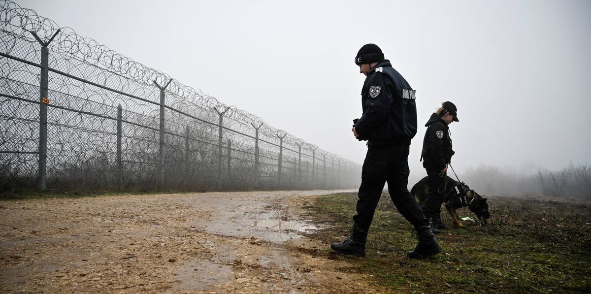 Bulgarian border police officers patrol with a dog in front of the border fence on the Bulgaria-Turkey border near the village of Lesovo on January 13, 2023. (Photo by Nikolay DOYCHINOV / AFP)