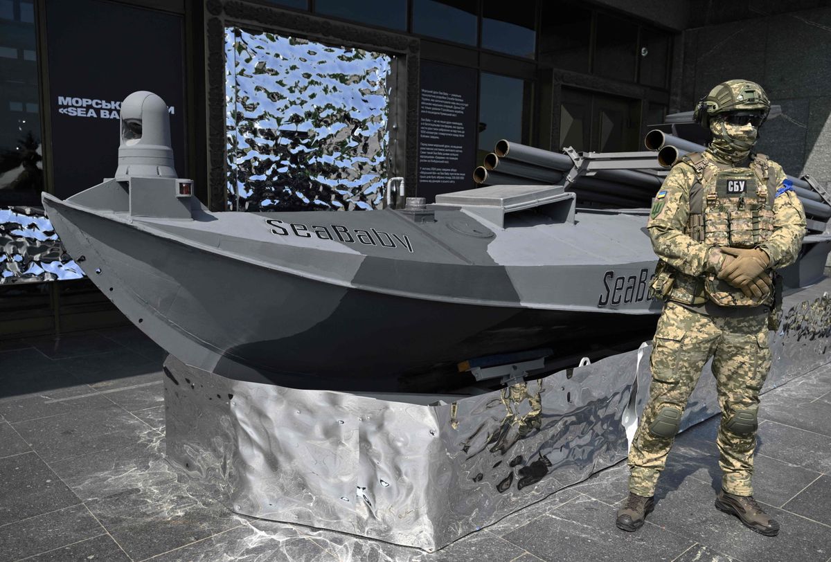 Un militaire du Service de sécurité de l'Ukraine se tient à côté d'un drone marin « SeaBaby »