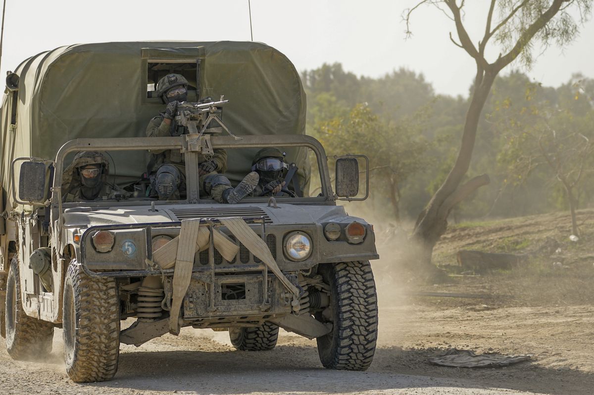 Israeli soldiers are seen at a staging area near the border with Gaza Strip, in southern Israel on Thursday, Nov. 23, 2023. (AP Photo/Ohad Zwigenberg)