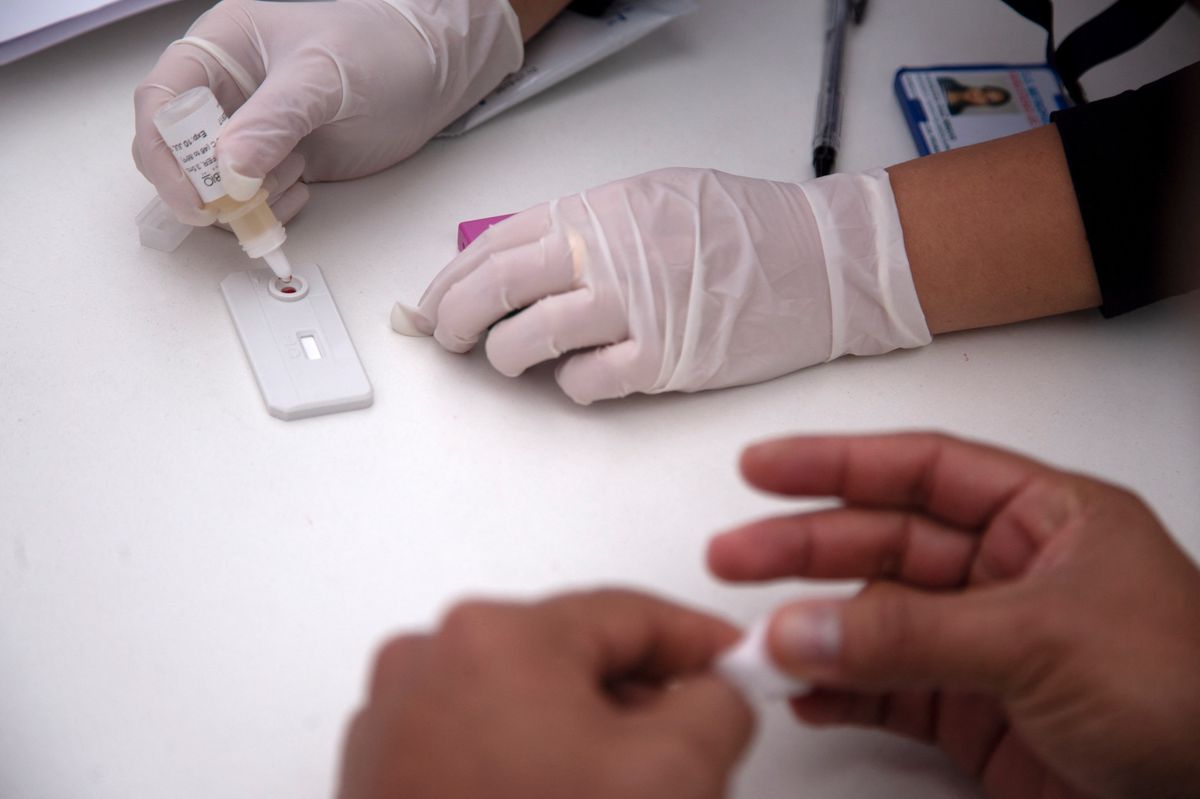 A man undergoes a rapid VIH test during the Gay Pride Parade in Santiago on June 23, 2018. The initiative aims to encourage prevention, as there is concern about the alarming increase of new HIV infections (Acquired Immunodeficiency Virus) in the country. (Photo by CLAUDIO REYES / AFP)