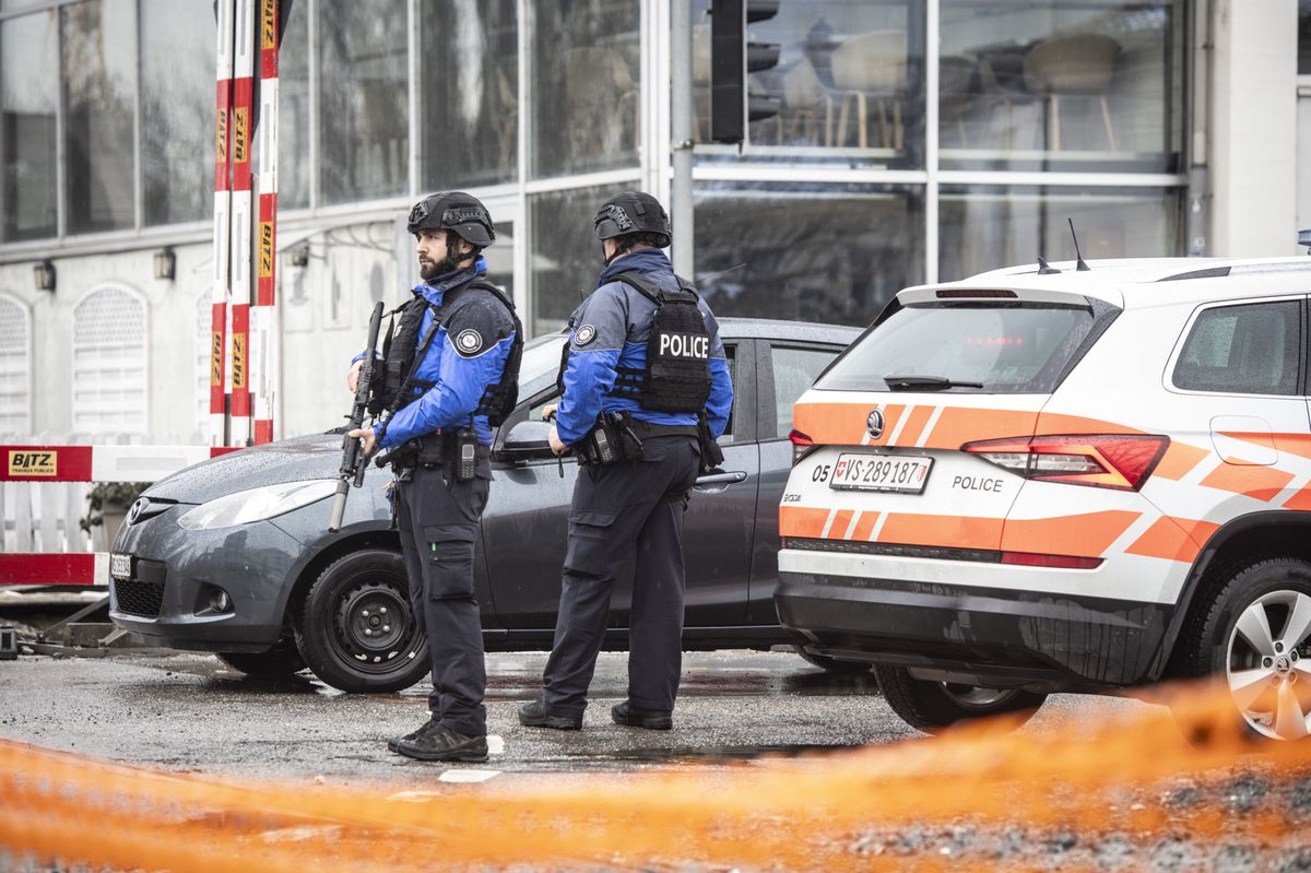 epa11022876 Police patrol a cordoned off road in Sion, Switzerland, 11 December 2023. A manhunt was underway after two people were killed and another one was injured when an individual fired several shots at two separate locations in Sion on the morning of 11 December, according to the police of the canton of Valais.  EPA/Louis Dasselborne