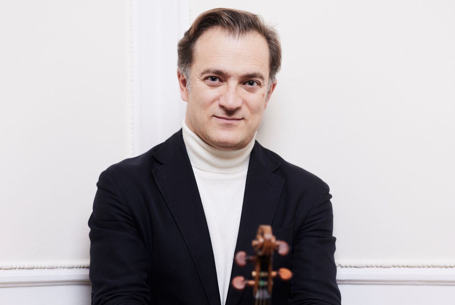 Portrait du violoniste virtuose et chef de l'Orchestre de chambre de Lausanne, Renaud Capuçon, tenant son violon dans les salons du Beau-Rivage Palace à Lausanne.