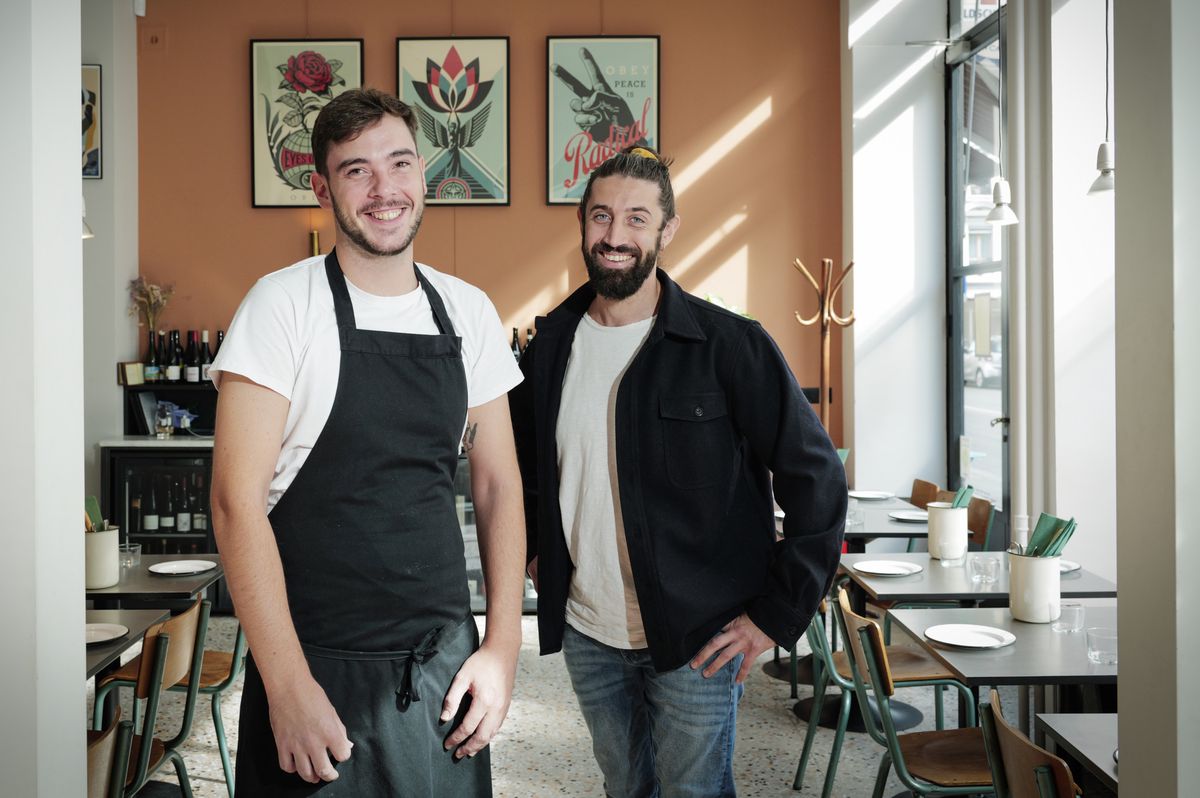 Pierre Lelièvre et Valentin Pouzet posent dans le restaurant Coin Coin à Genève, près des tables et de décorations murales.