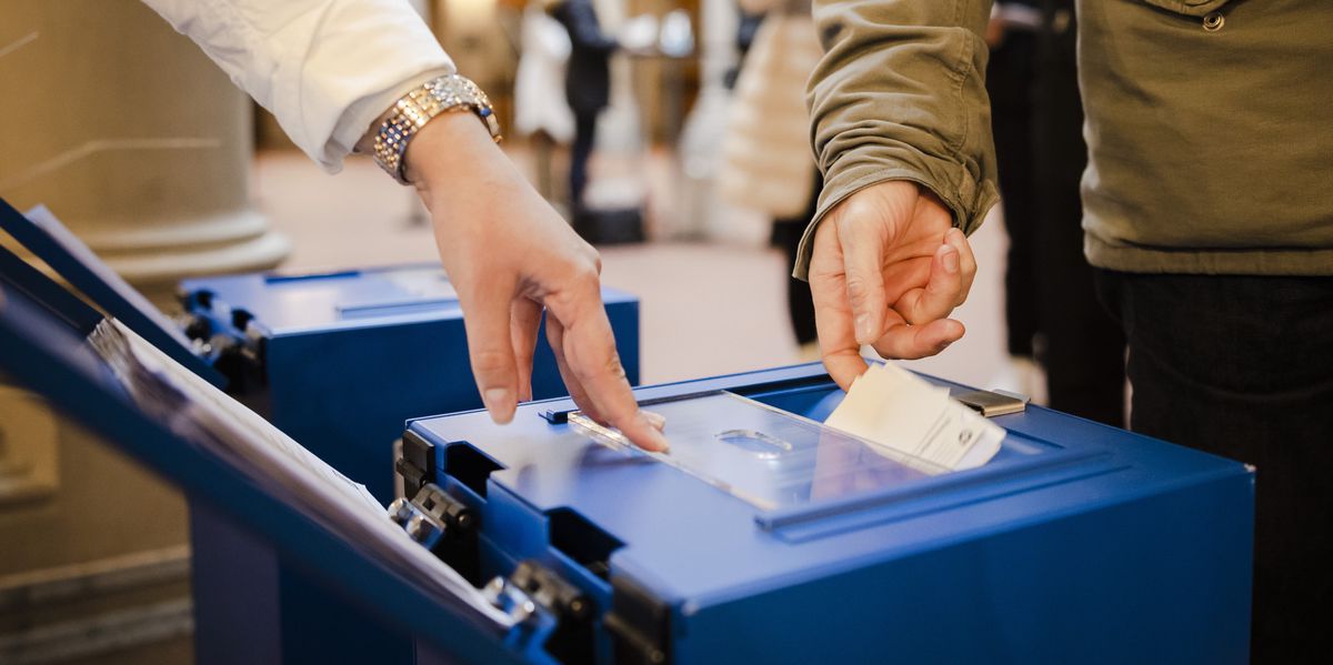 Des électeurs déposent leurs bulletins de vote dans l'urne de vote au Stadthaus de Zurich, le dimanche 28 novembre 2021, lors des votes nationaux, cantonaux et communaux suisses.