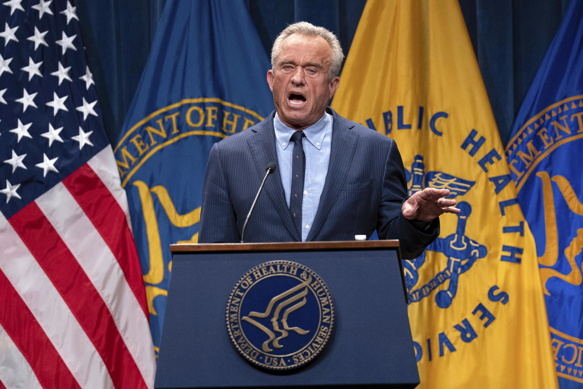 Robert F. Kennedy Jr. spricht auf einer Pressekonferenz im Hubert Humphrey Building Auditorium, Washington, vor Flaggen.