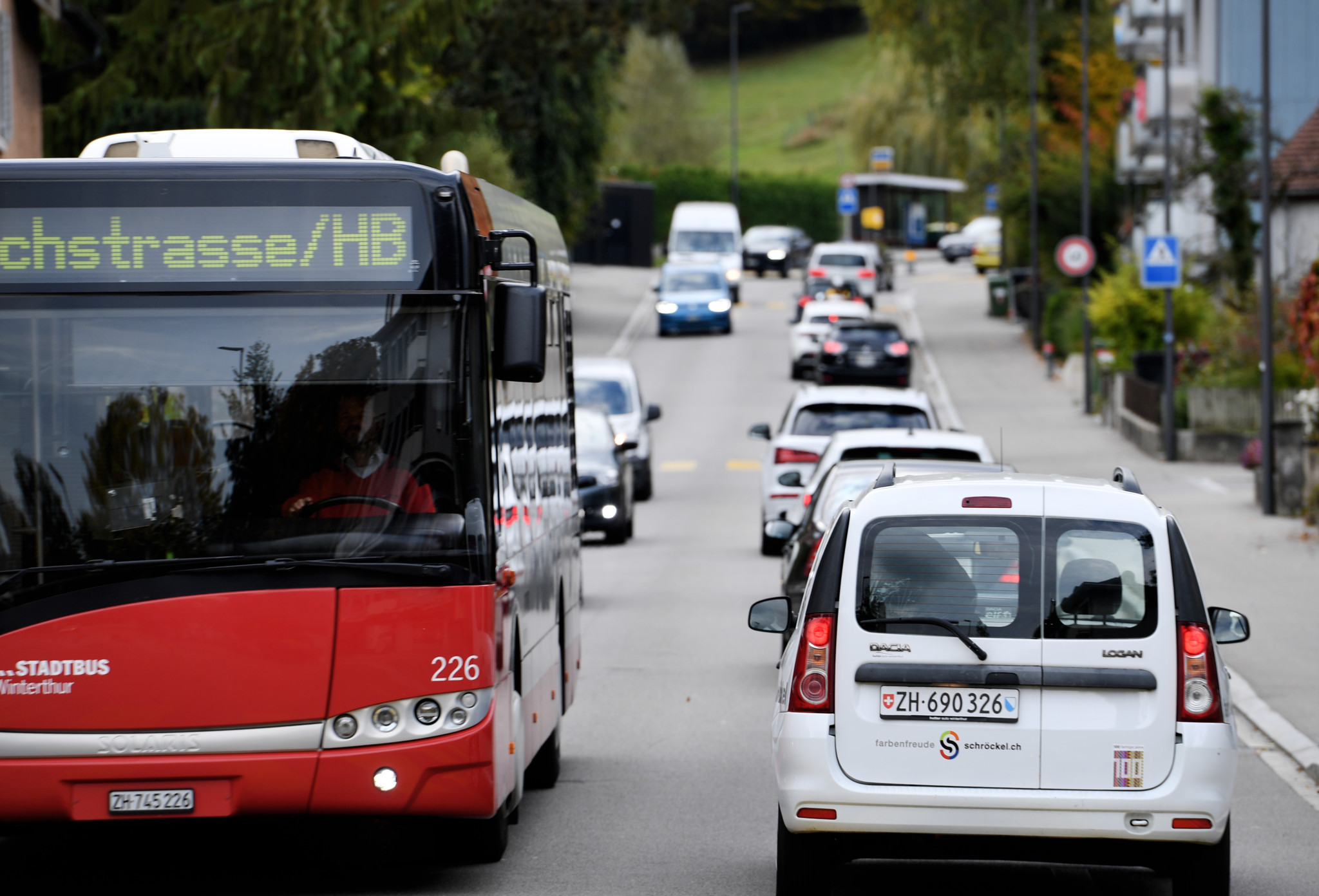 Verkehr auf der Breitestrasse in Winterthur mit einem roten Stadtbus und mehreren Autos.