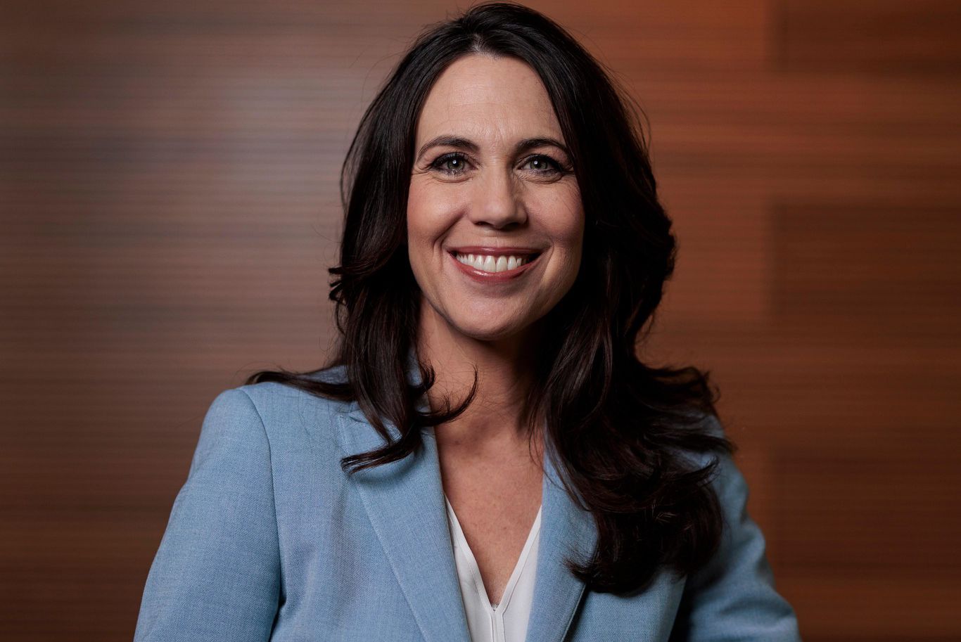 Une femme en costume bleu, souriant, contre un fond en bois, à Berne, le 6 décembre 2024.