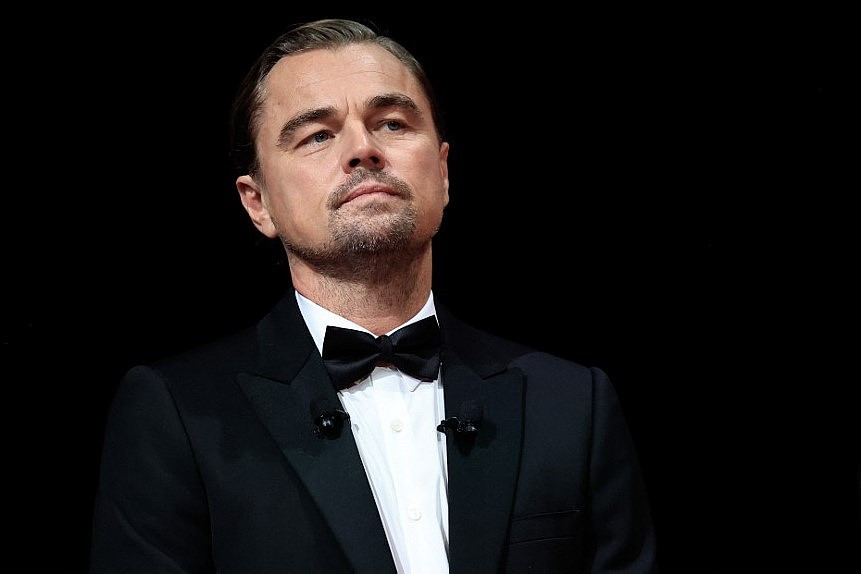 Leonardo DiCaprio im Smoking bei der Eröffnungszeremonie der Filmfestspiele von Cannes 2025. Er hört aufmerksam zu.