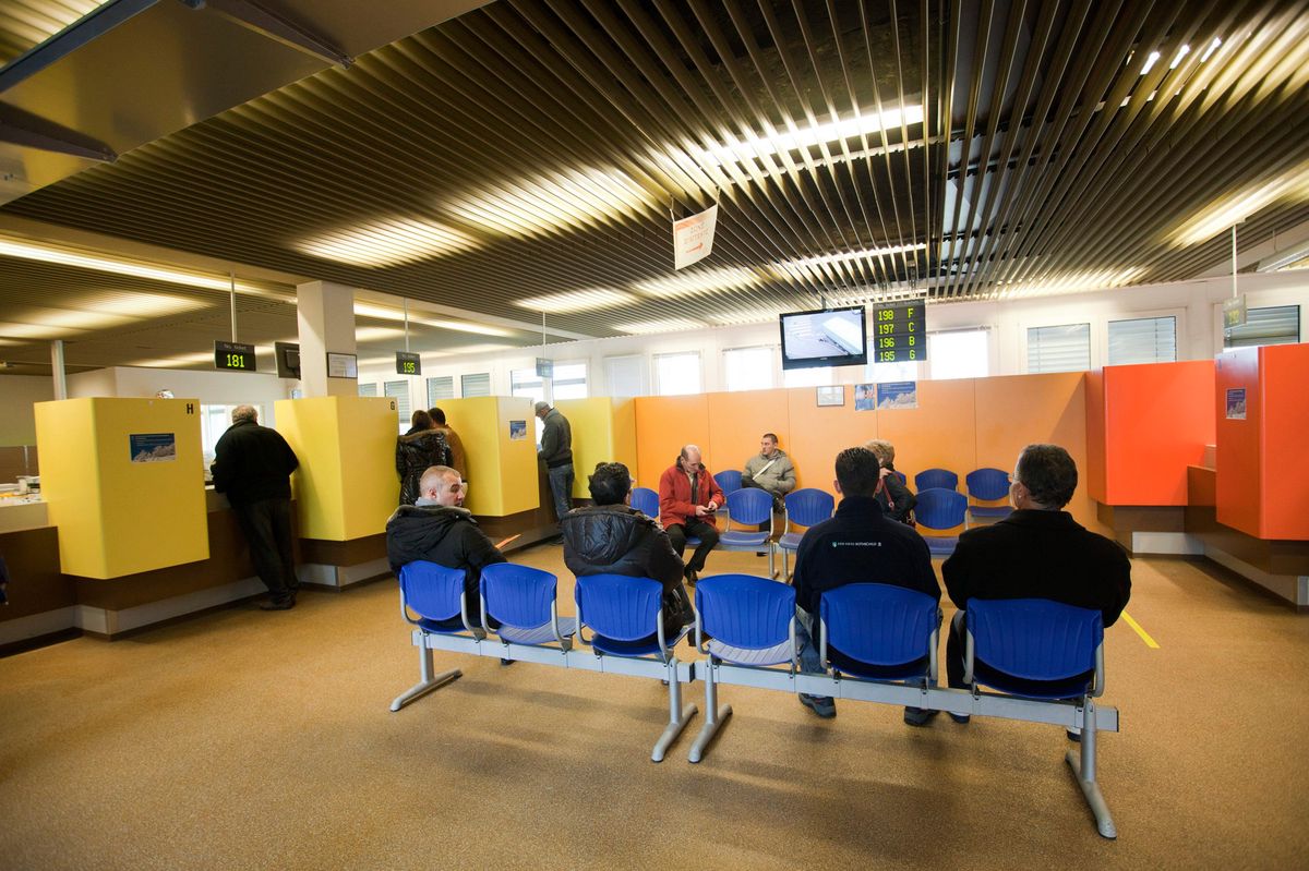 Des personnes assises et debout attendant devant les guichets au Service des automobiles et de la navigation (SAN) à Lausanne, le 28 décembre 2011.